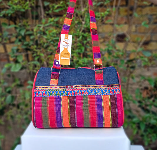 Colourful handbag made with traditional handwoven material and denim, embellished with hand embroidery. Useful for carrying around your necessities while making a fashion statement. Made in Pakistan