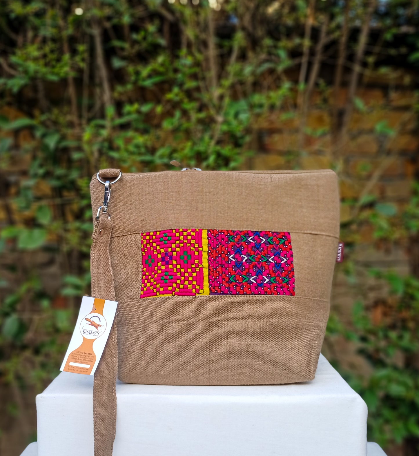 Fashionable cross body bag made with handwoven fabric and embellished with hand embroidery. With an adjustable strap and waterproof lining. Perfect for carrying around your daily accessories.