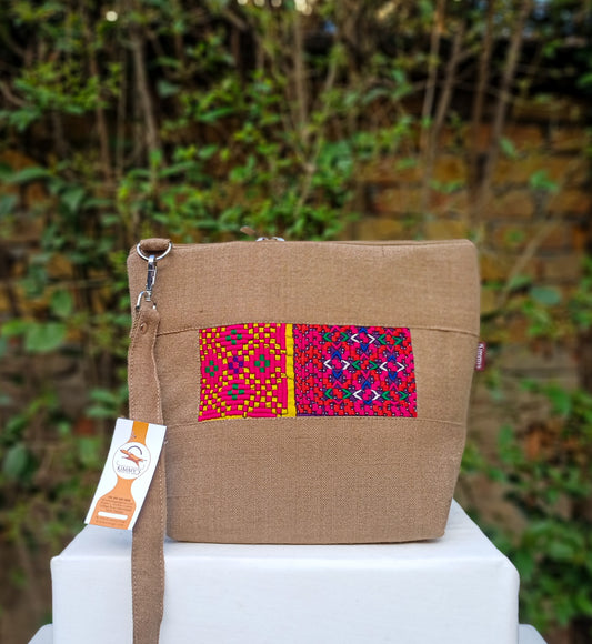 Fashionable cross body bag made with handwoven fabric and embellished with hand embroidery. With an adjustable strap and waterproof lining. Perfect for carrying around your daily accessories.