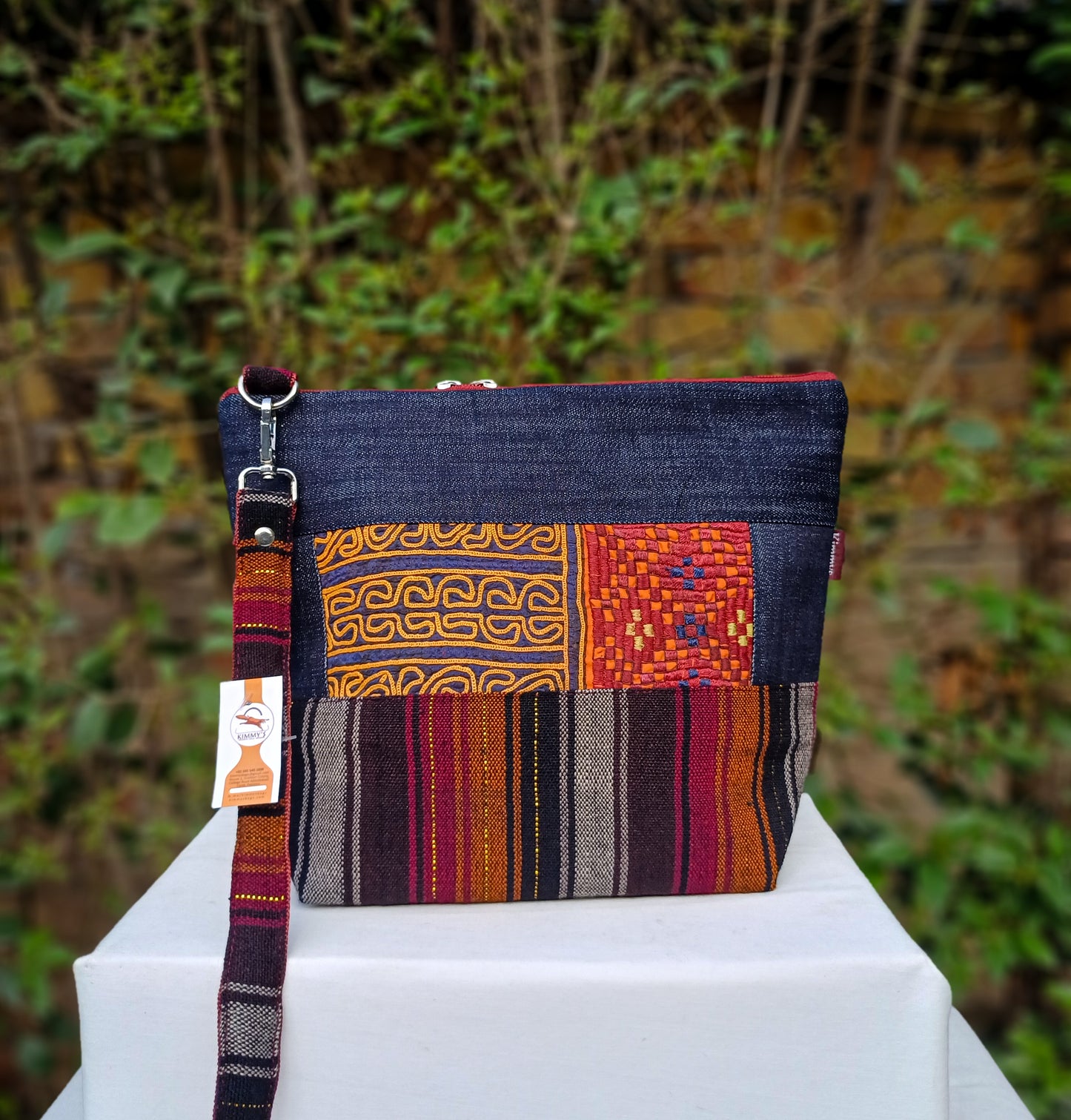 Fashionable cross body bag made with handwoven fabric and denim. Embellished with hand embroidery. With an adjustable strap and waterproof lining. Perfect for carrying around your daily accessories.